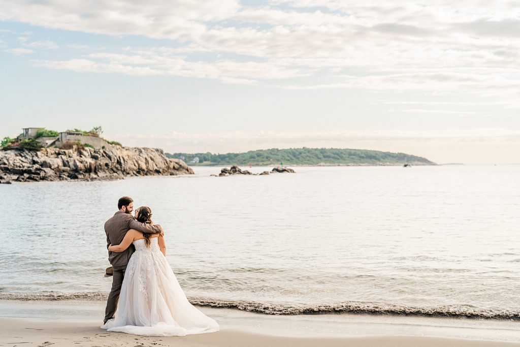 A couple enjoying the sunrise during their Portland Maine elopement | how to elope in Portland Maine